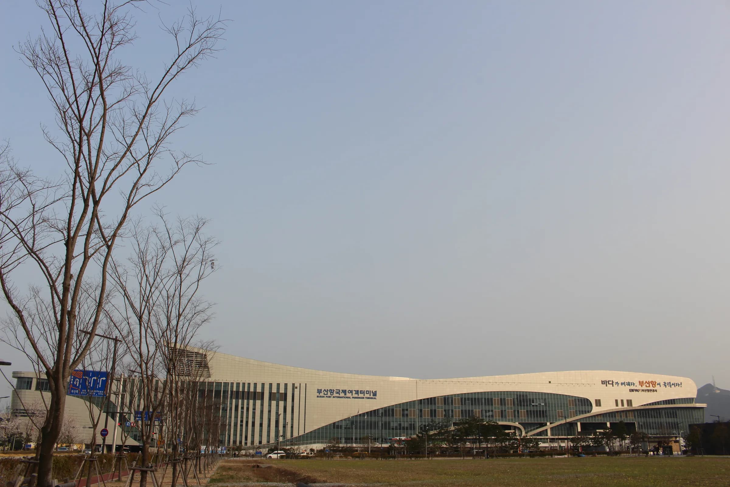 Busan Port International Passenger Terminal — the long wave-roofed building where the Hakata ferry checks in, seen across the forecourt